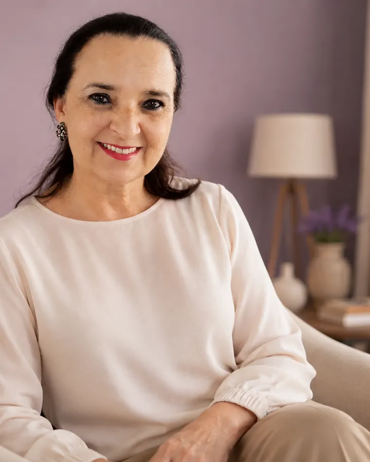 Regiani Werner sentada na poltrona do consultório, sorrindo.
